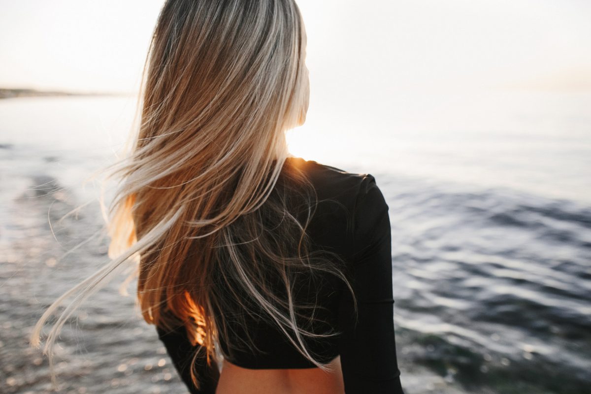 blonde girl with highlights staring at the sunrise